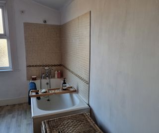 A bathroom with beige tiles and walls newly painted with white anti-condensation paint