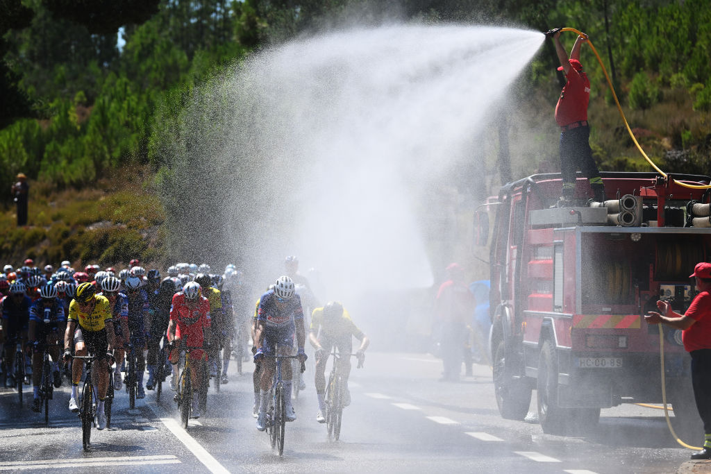 CASTELO BRANCO, PORTUGAL - AUGUST 19: The fire service refreshes the peloton during during the La Vuelta - 79th Tour of Spain 2024, Stage 3 a 191.5km stage from Lousa to Castelo Branco / #UCIWT / on August 19, 2024 in Castelo Branco, Portugal. (Photo by Dario Belingheri/Getty Images)