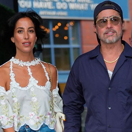 Ines de ramon wears a floral blouse. Brad pitt wears a navy blazer.