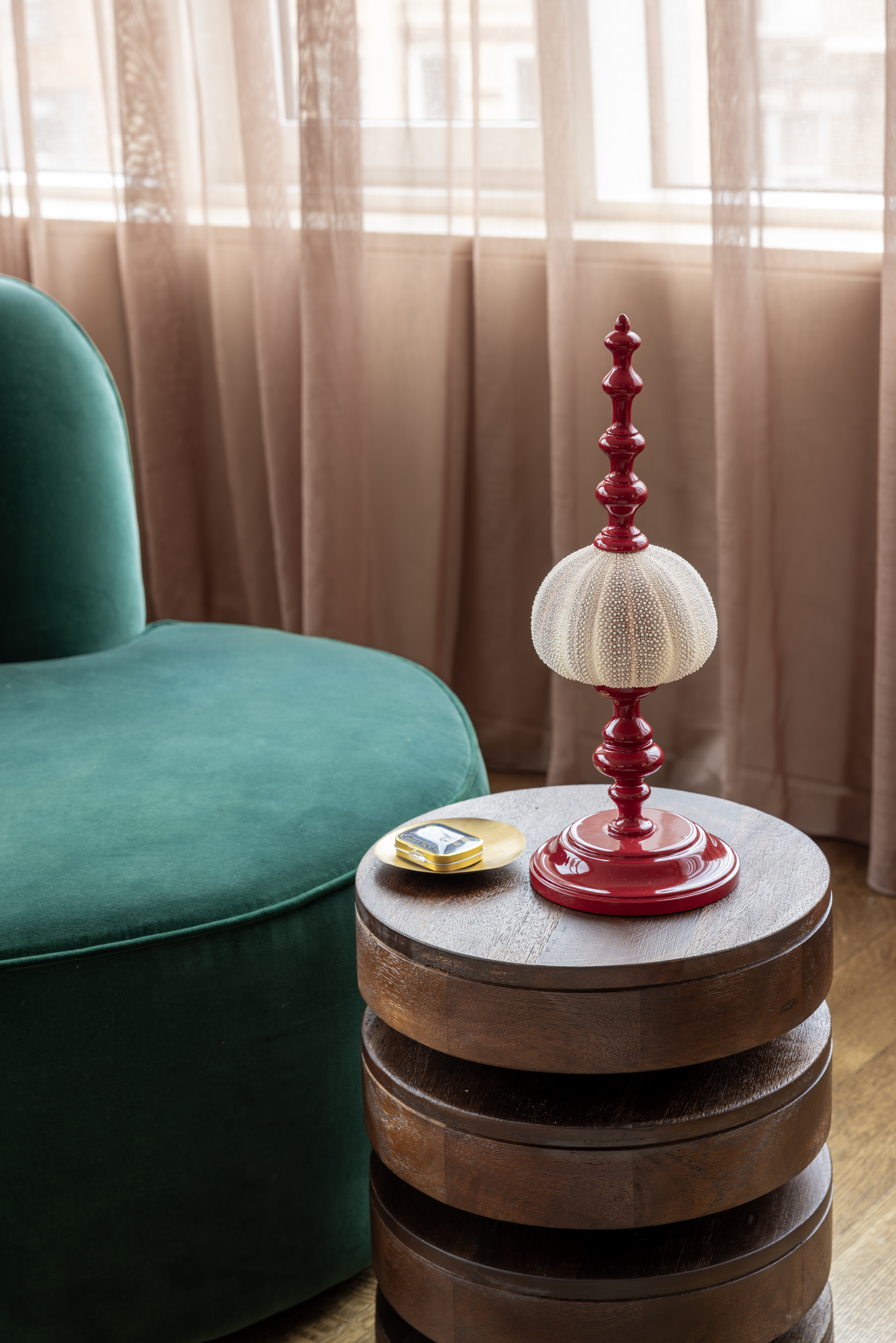A small, dark green chair with a compact, round side table 