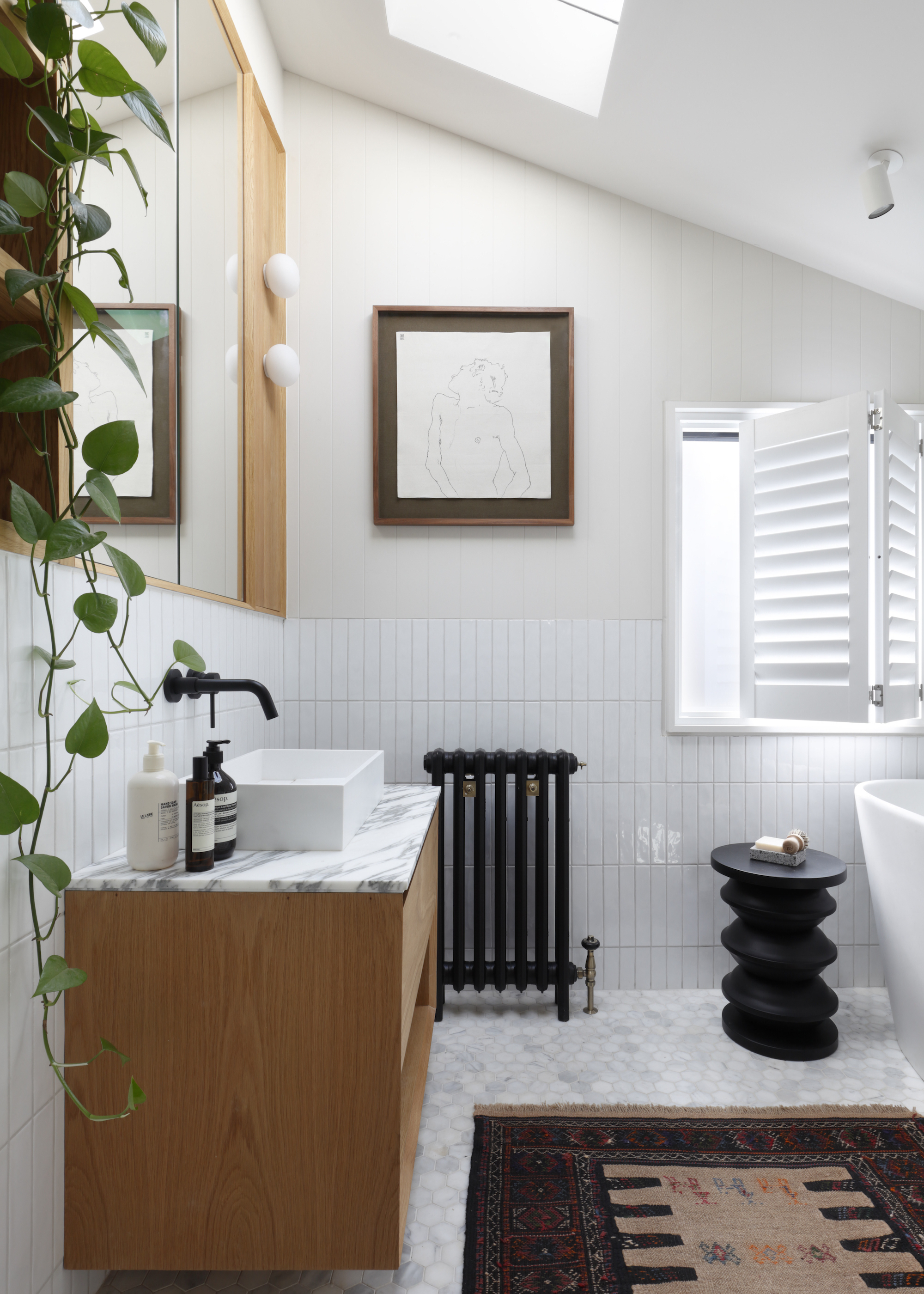 white loft bathroom with wood furniture and black fittings