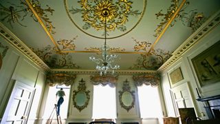 A man checks the windows in the north drawing room at Dumfries House