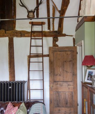 antique ladder against beamed walls in Tudor house