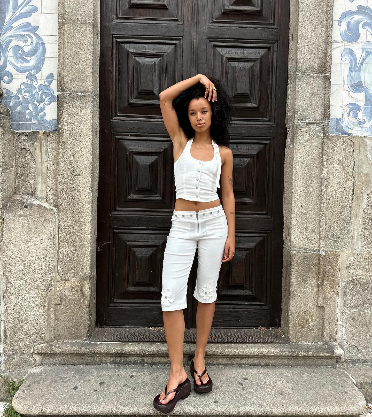 An image of @fiahamelijnck showcasing how to wear pedal pushers with white pants, a white halterneck top and platform flip-flops.