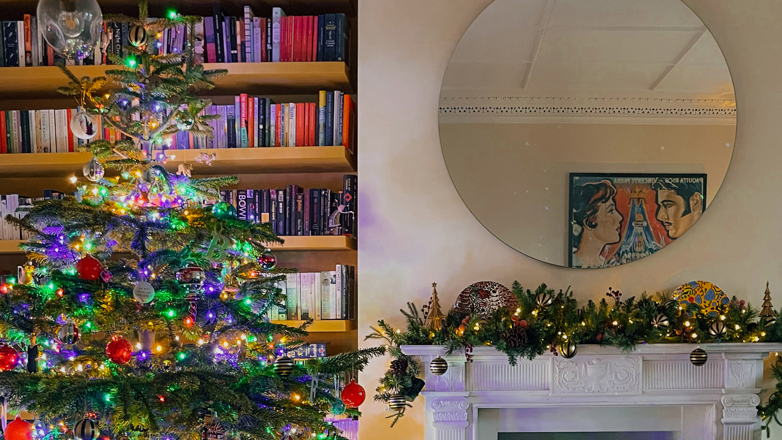 lit christmas tree and garland over a fireplace