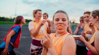 Netball team eating oranges