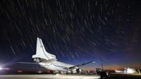 the flight path of a plane is shown around an airland, landing strip, and a small white rocket on the bottom right.
