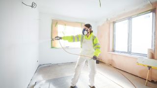 woman using paint sprayer for walls