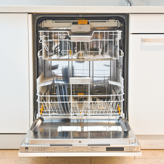 Open dishwasher in white cabinets