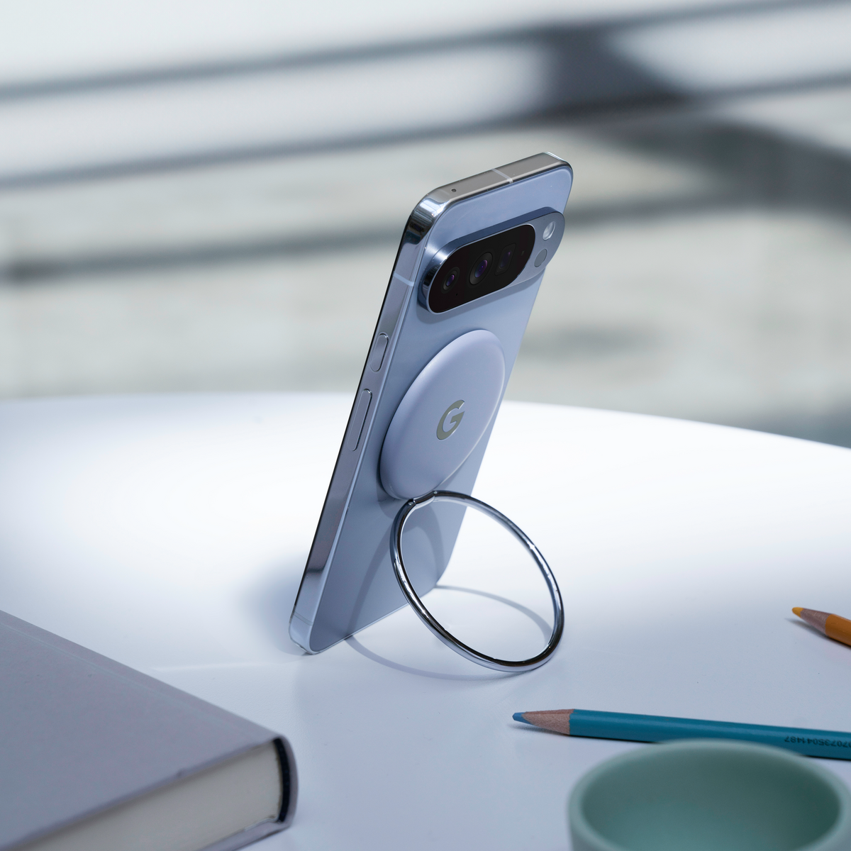 Google Pixel 10 phone propped up on a magnetic ring stand