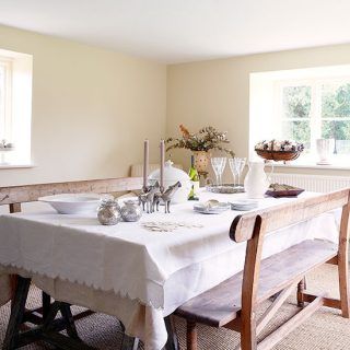 dinning room with dinning table and bench cream colour wall window and plates glasses