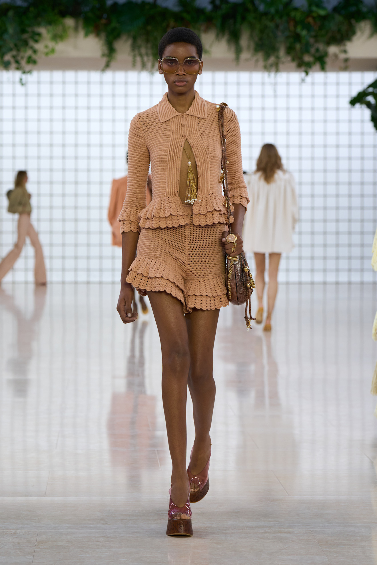 A model wearing wooden clogs at Chloé Spring 2025 show with a knit set