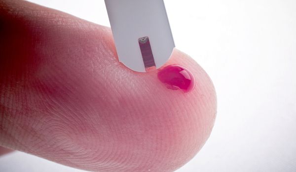 A person checks their blood sugar levels with a blood glucose meter.