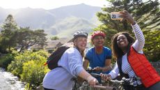 Three smiling mature women taking a selfie on a bike ride in the countryside