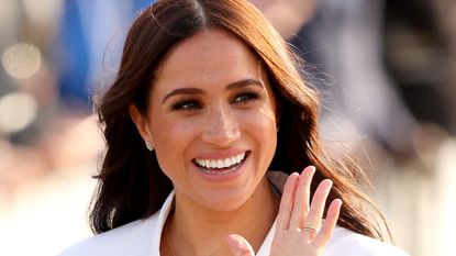 Meghan Markle in a white suit waving