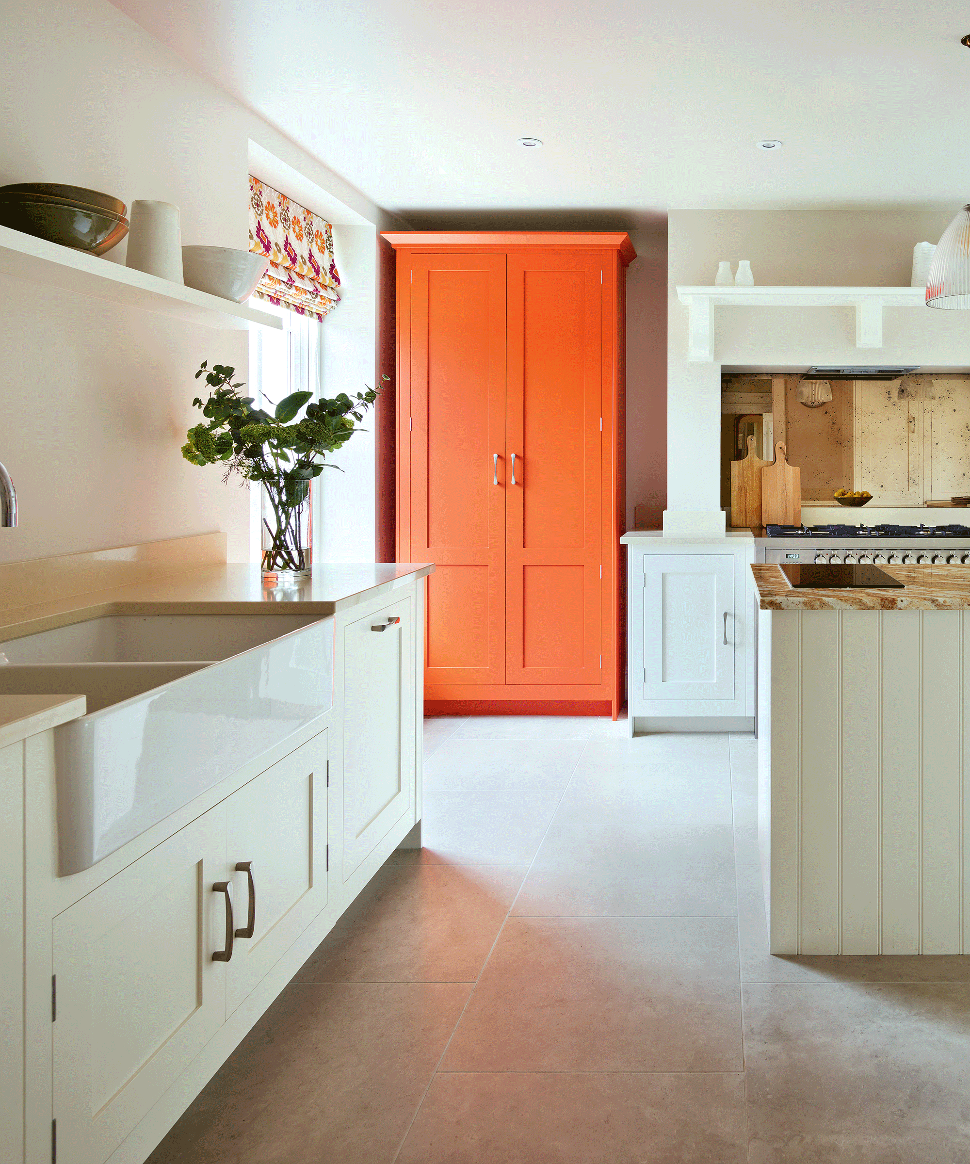An example of freestanding kitchens showing an orange freestanding kitchen pantry cupboard in a cream kitchen