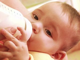 A baby drinks from a bottle