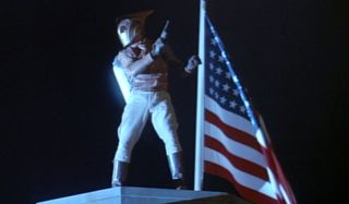 The Rocketeer posing next to the American flag.