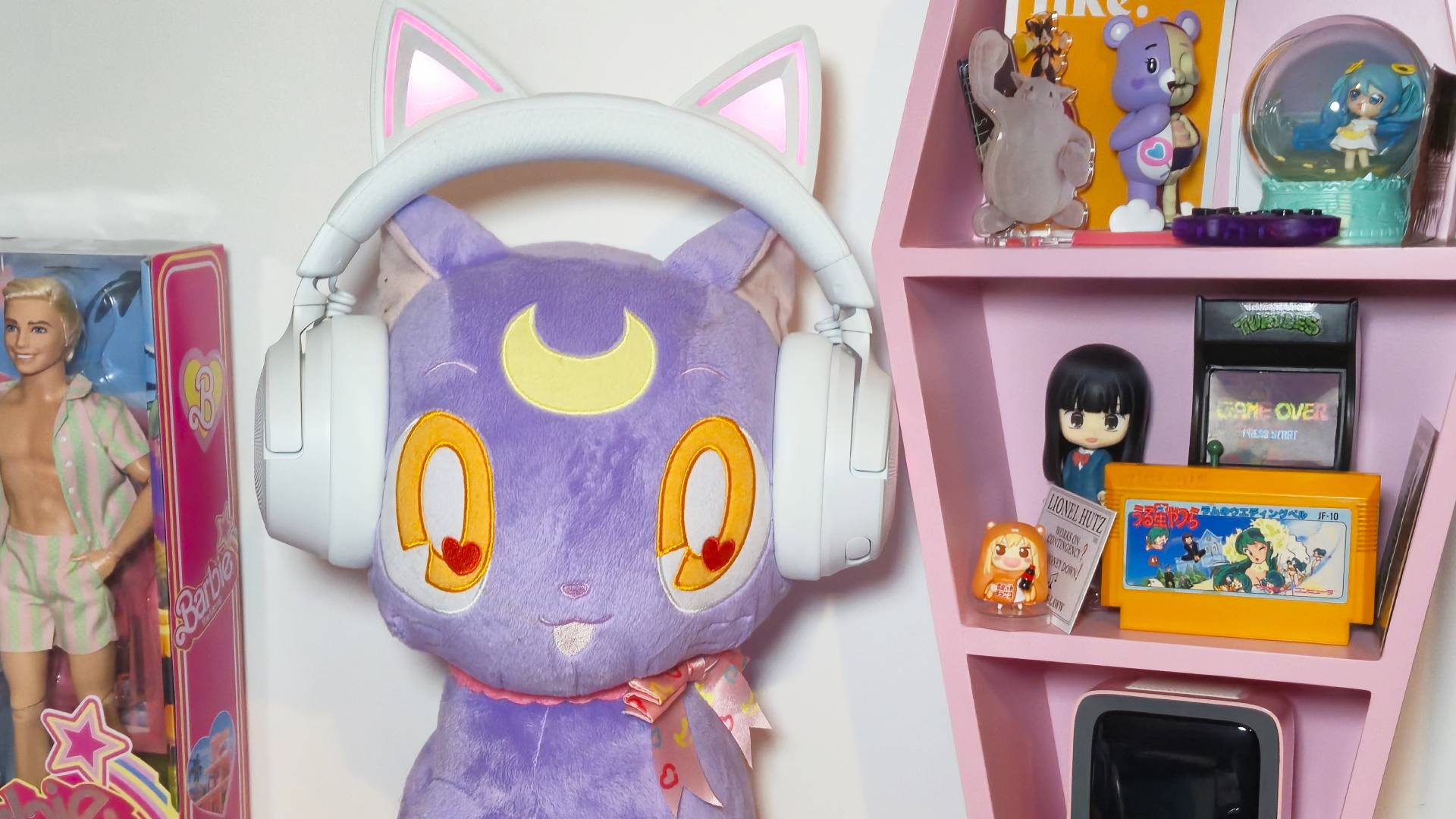 Photo of a big large plushie of Luna from the anime Sailor Moon wearing a white Razer headset with cat ears.