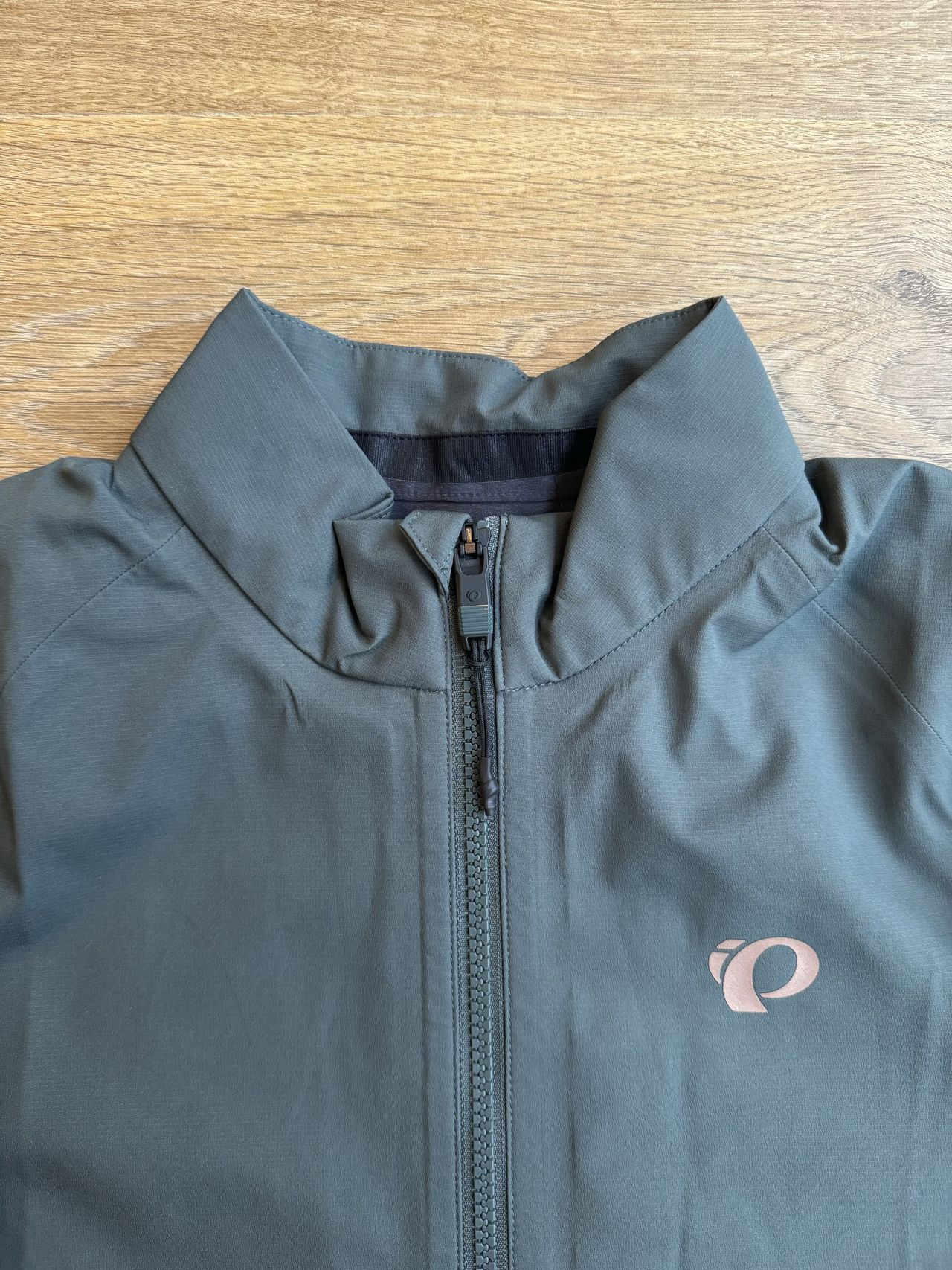Flat lay jacket, collar and zip with small pearl izumi logo on the right breast