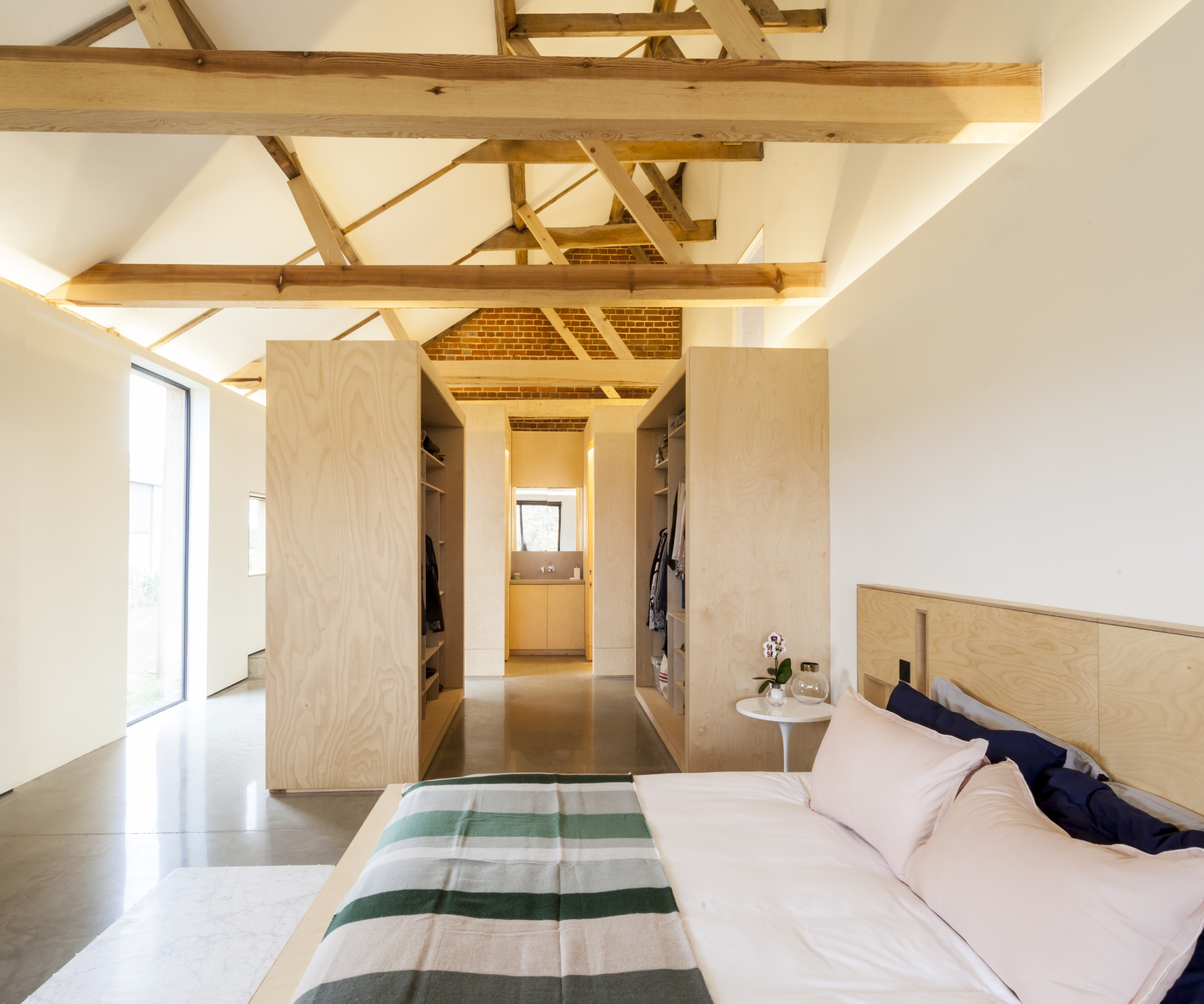 bedroom in barn conversion with storage creating wall dividers rather than walls