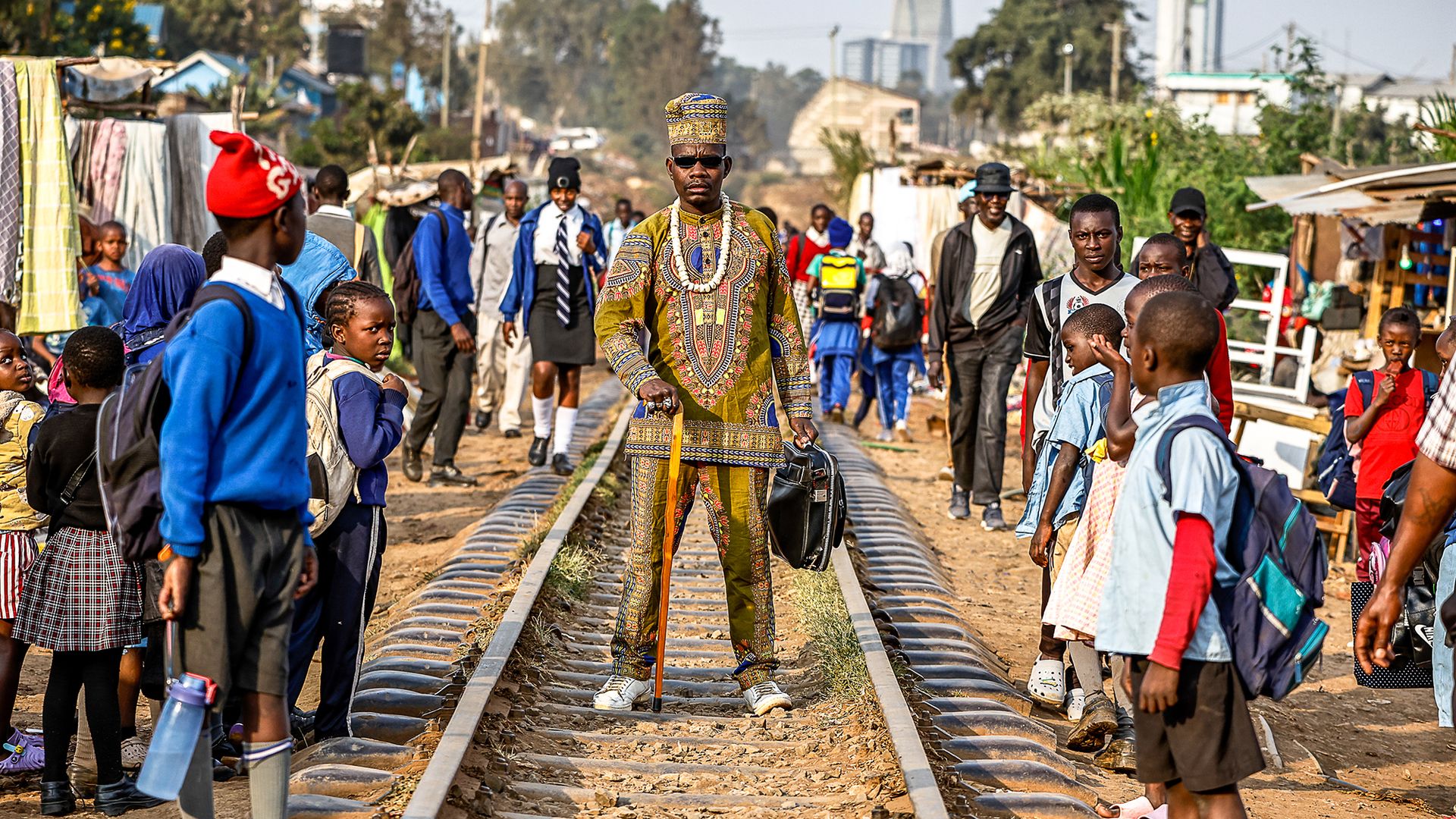 
                                A man wearing a traditional fabric outfit poses in Nairobi's Kibera neighborhood in Kenya
                            
