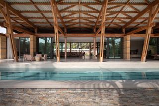 this retreat in the Ivory Coast features open plan interiors and large glazed facades that open up to nature and a swimming pool