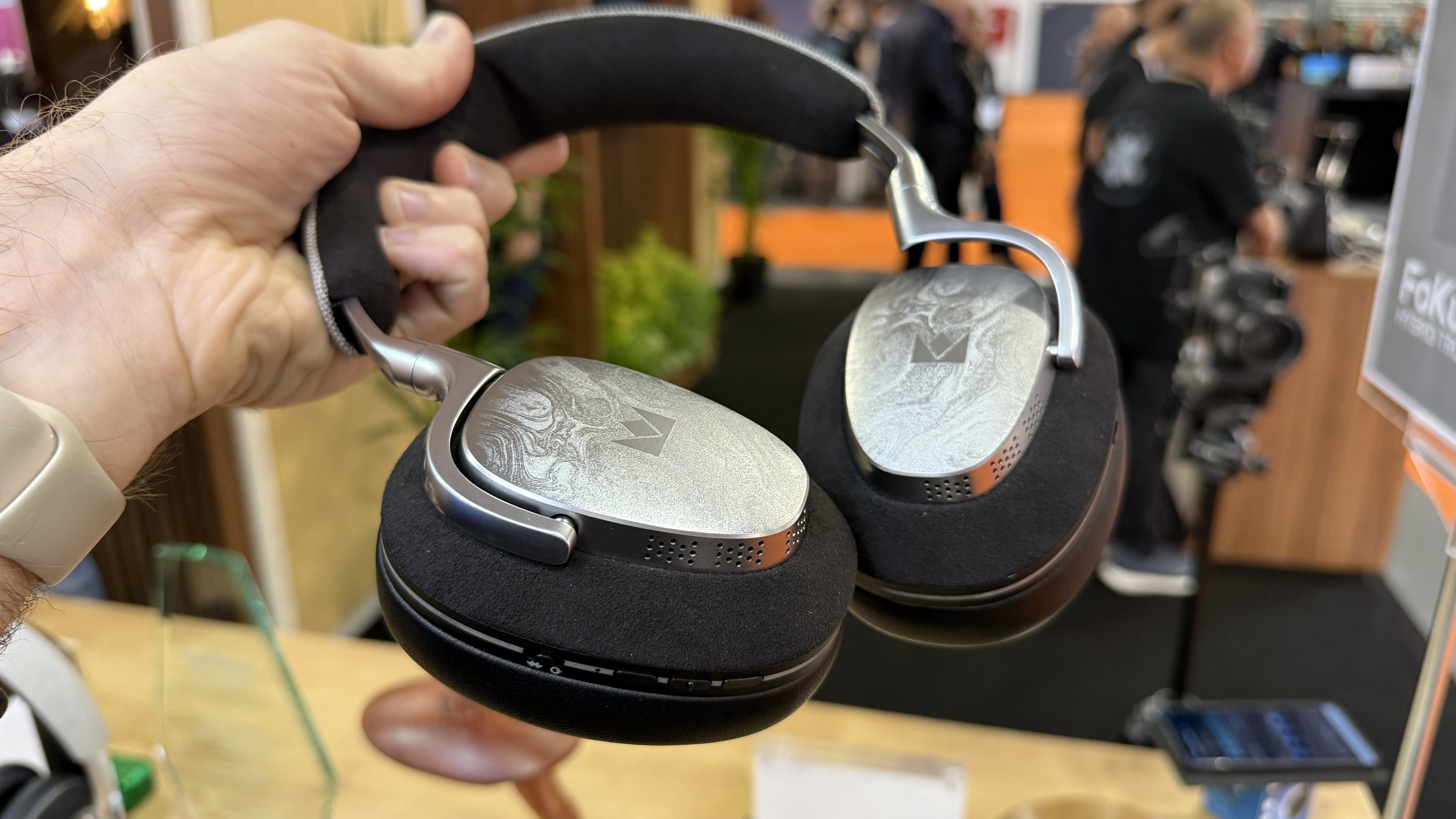 The Noble Fokus Artemis held in a man's hand at the high end show, demonstrating their svelte design