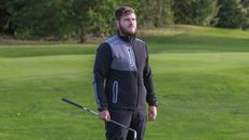 A golfer wears a Puma Nordic DWR Golf Jacket