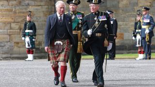 King Charles speaks with a member of the Scottish Military during the Royal Family's Royal Week