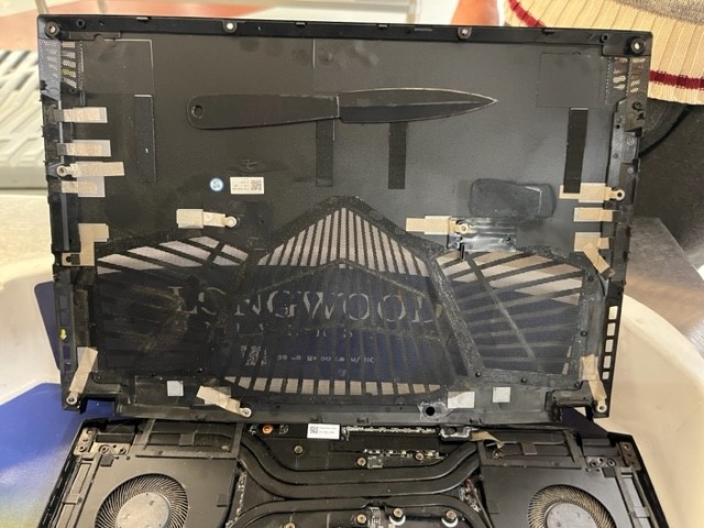 A black knife taped into a laptop chassis.