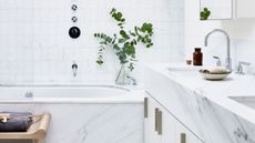 White small bathroom with marble vanity and bath