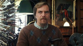Michael Shannon sitting in front of the wall of knives in Knives Out.