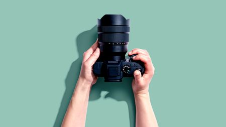 Person holding a SLR camera from above
