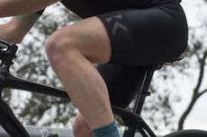 A close up of a white male in cycling shorts sitting on a saddle 