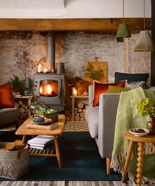cozy living room with woodburning stove, grey sofa and Ercol coffee table on black rug.