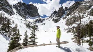 A man hiking in a snowy mountain bowl