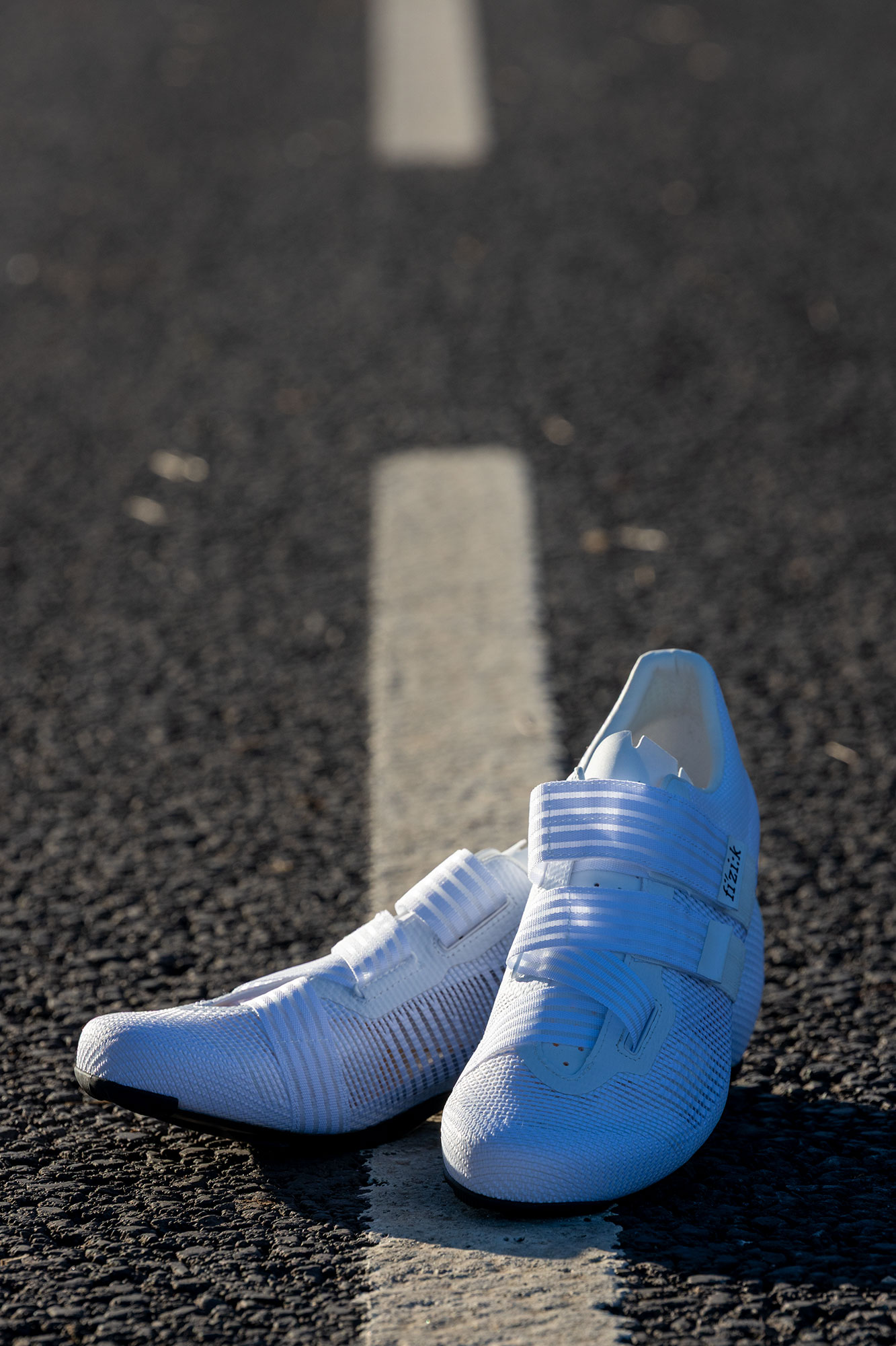 Fizik Powerstrap Aeroweave shoes positioned on a white line in the road
