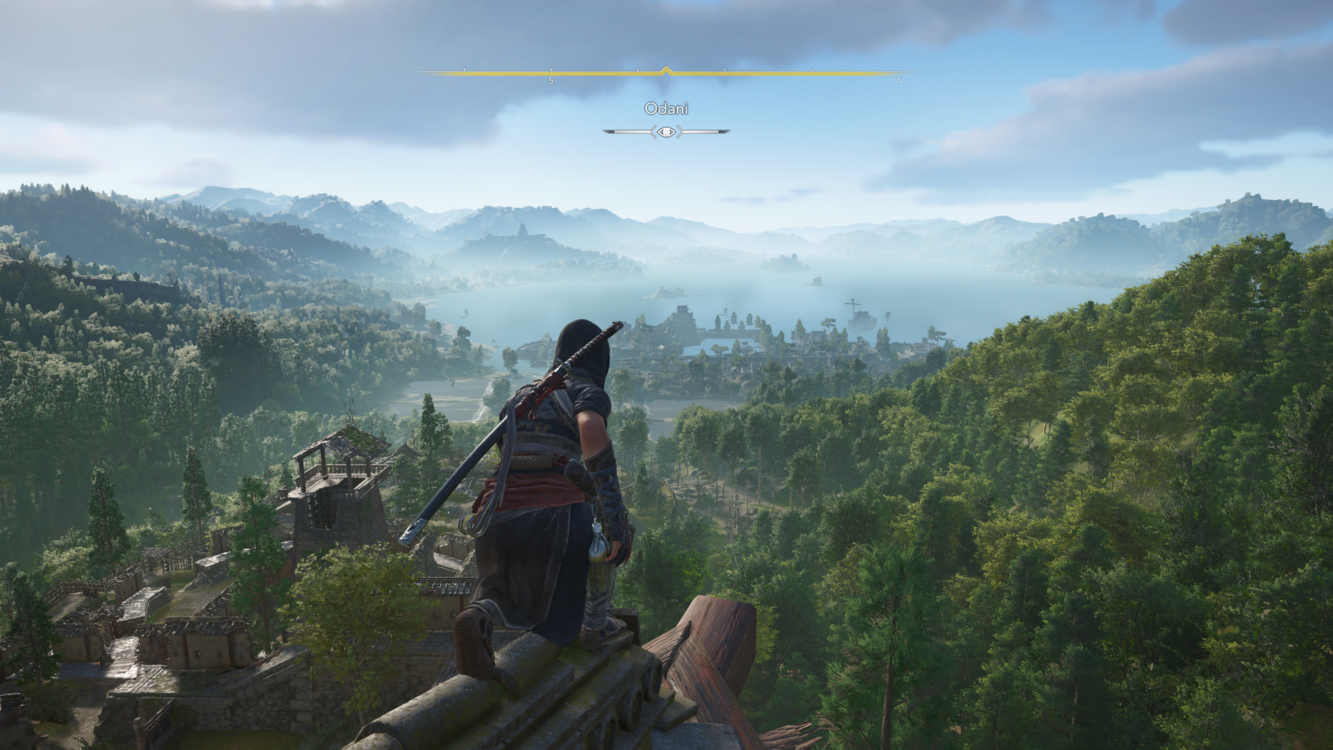 In Assassin's Creed Shadows, Naoe perches on a rooftop and looks out over the expansive landscape of Odani