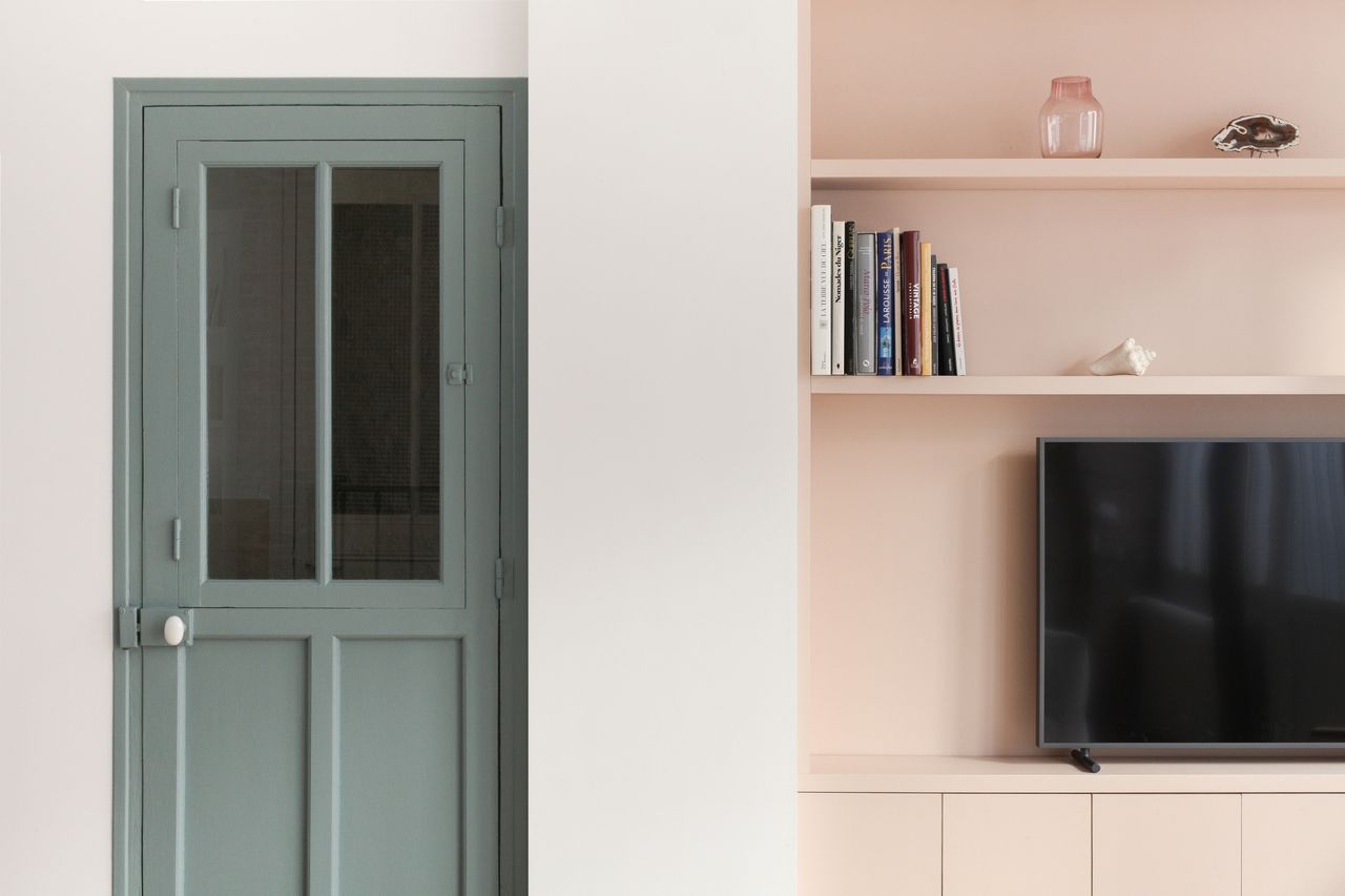 A room with pink walls and green door