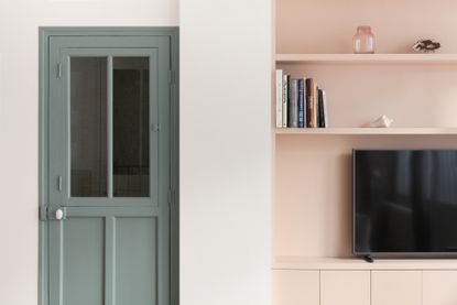 A room with pink walls and green door