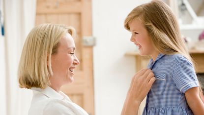 School uniform girl getting dressed with mum