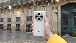 The Oppo Find X8 Pro against some buildings with snowfall