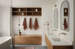 A neutral bathroom with wooden storage bench