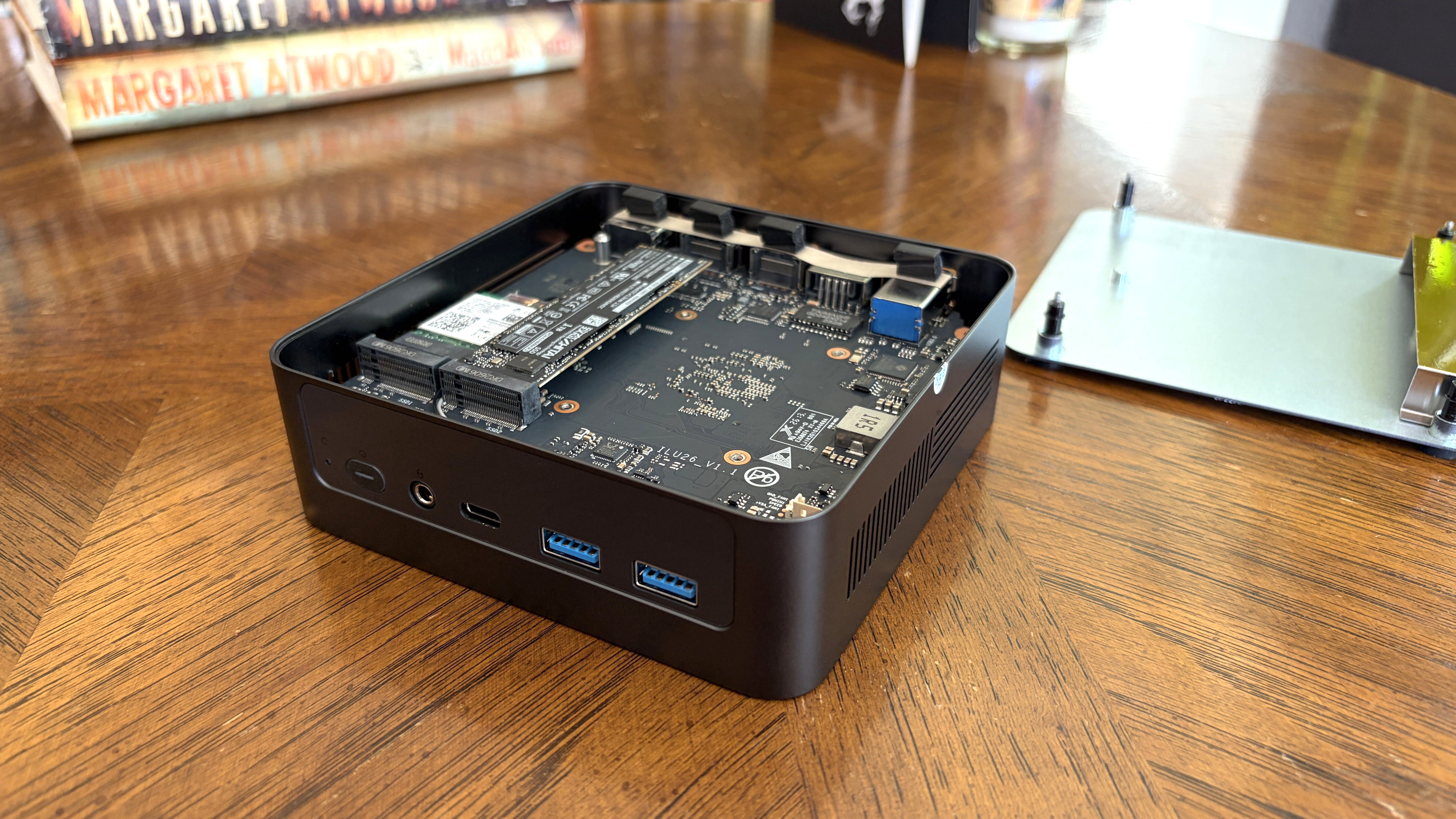Open Chuwi mini PC case with visible internal components on a wooden table.
