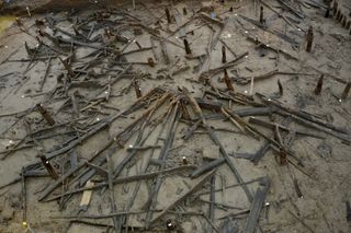 The remains of one of the Bronze-Age roundhouses at the Must Farm site, showing the rings of posts from the walls and collapsed roof timbers "like spokes in a wheel."