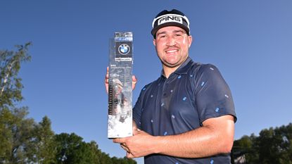 Thriston Lawrence holds up the 2023 BMW International Open trophy
