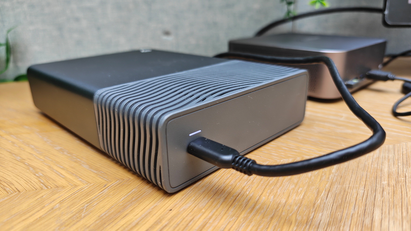 Photos of a silver grey HD box on a wooden desk