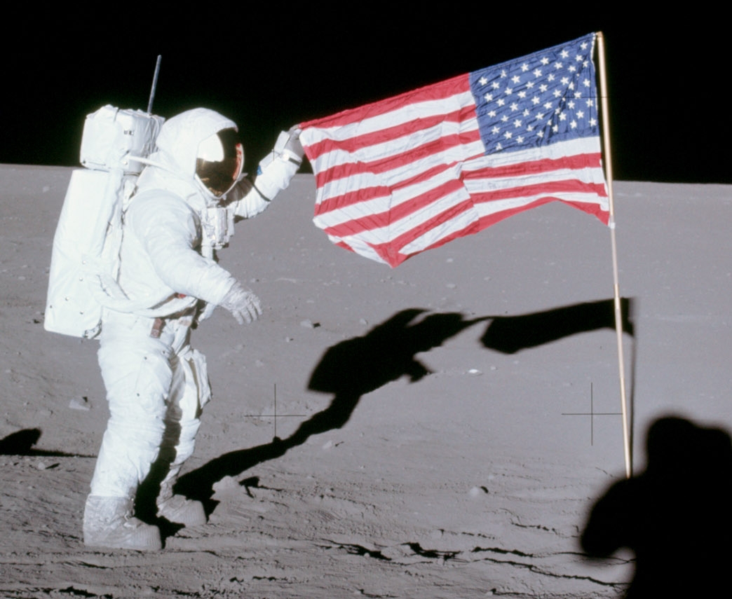 An Apollo moonwalker unfurls the American flag. In returning to the moon, this time to stay, what is the Artemis flag strategy?