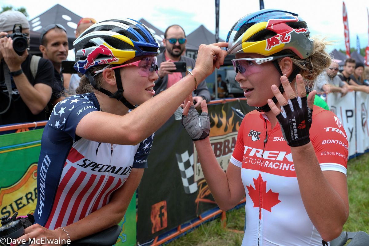 Kate Courtney (Specialized) and Emily Batty (Trek) talk about Red Bull helmets at the finish